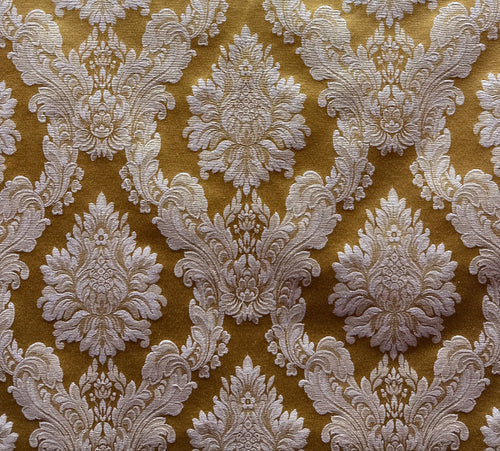 A close-up image of a golden yellow fabric with a white floral pattern.